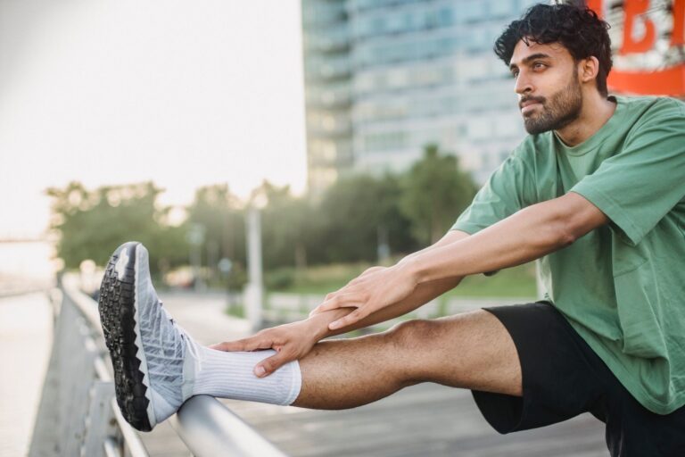 Courbatures dans les jambes sans — personne étirant les jambes après l'entraînement